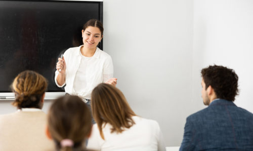 Kategoriebild Sprachen (Frau unterrichtet im Klassenzimmer)