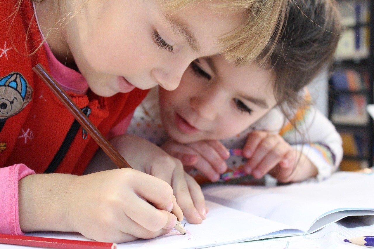 Zwei kleine Kinder malen am Tisch